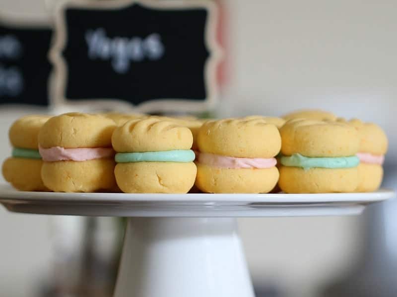 Blue and pink filled Yo Yo Biscuits on a white cake stand.