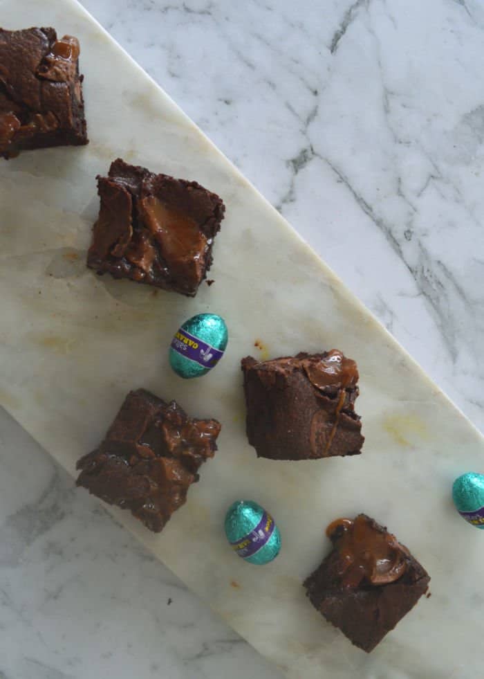 Caramel Brownies sitting on a marble tray with caramel easter eggs.