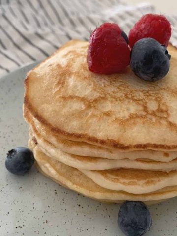 Stack of pancakes topped with berries
