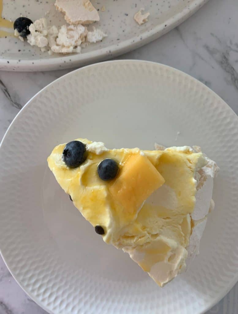 Pavlova topped with mango, passionfruit and blueberries