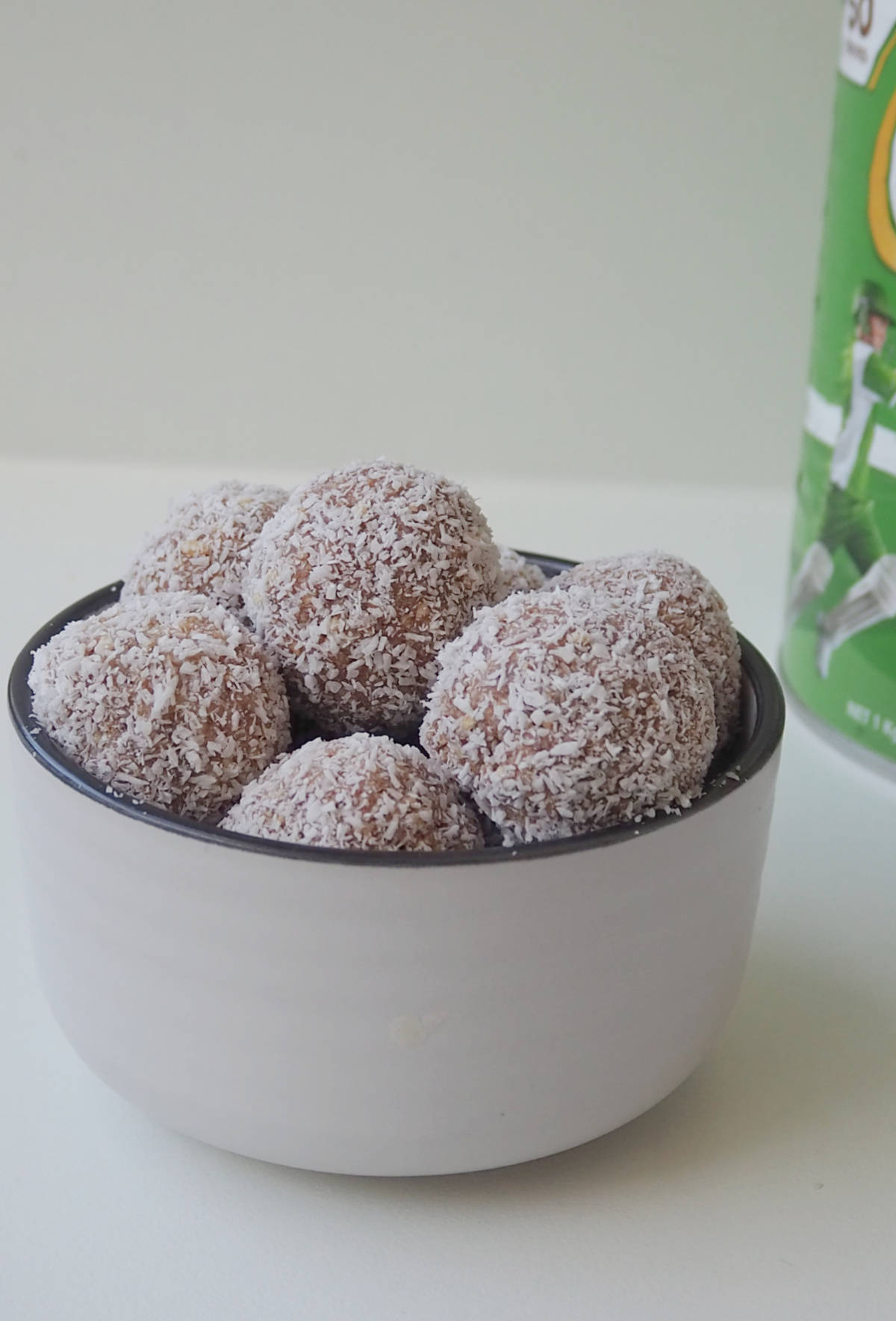 Milo Balls in a white bowl. in the background there is a tin of Milo.