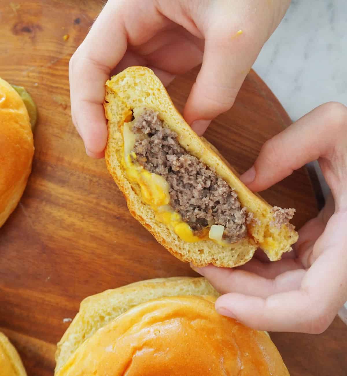 Cheeseburger cut in half being held by child