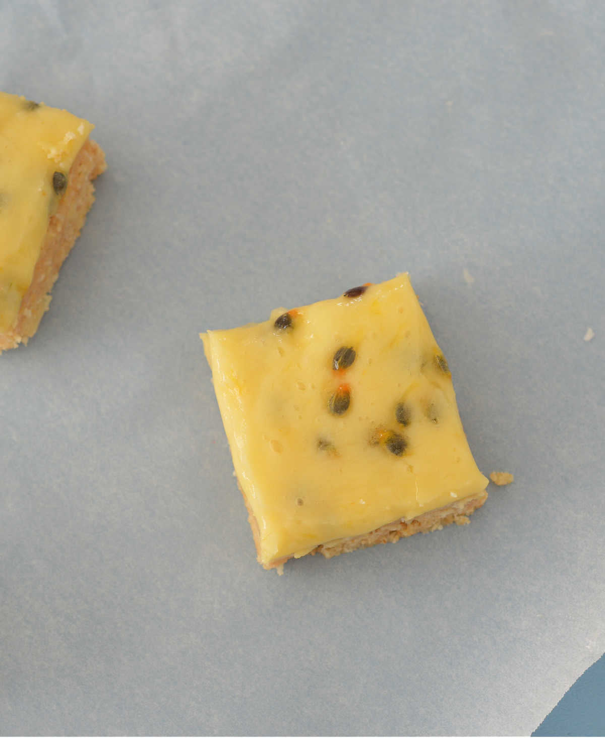 overhead view of passionfruit slice on a piece of baking paper