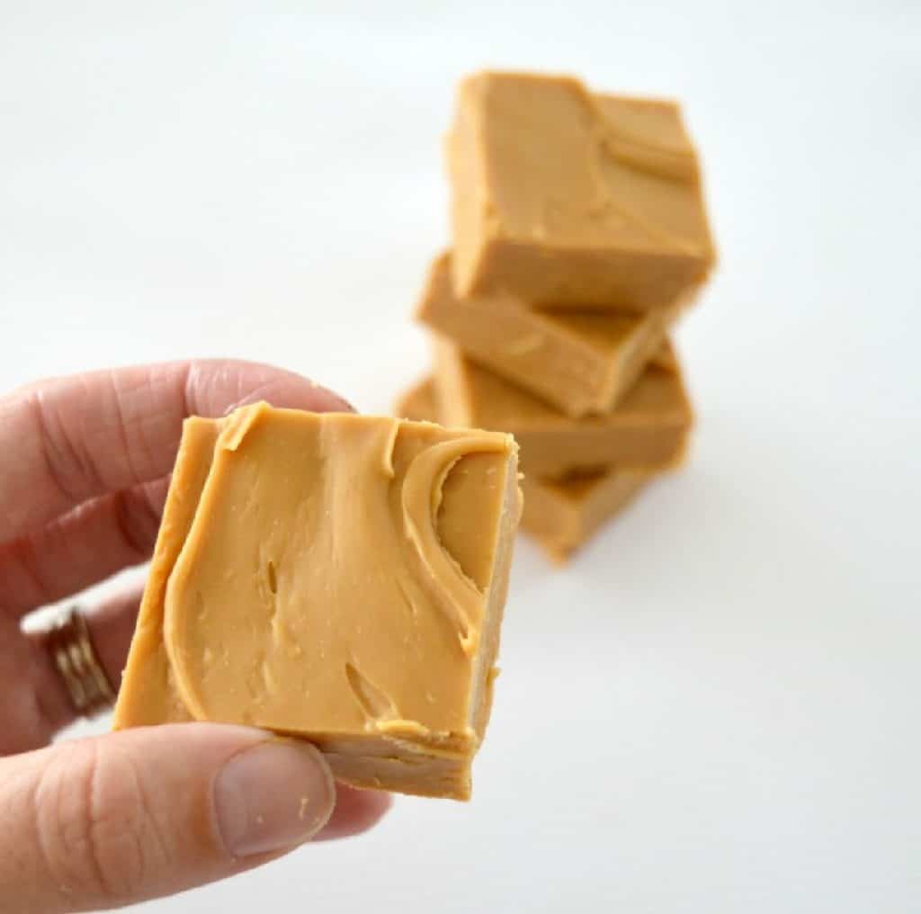 adult holding a piece of caramel fudge