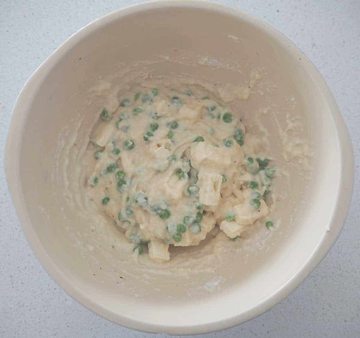 Mixture for pea fritters in a white bowl