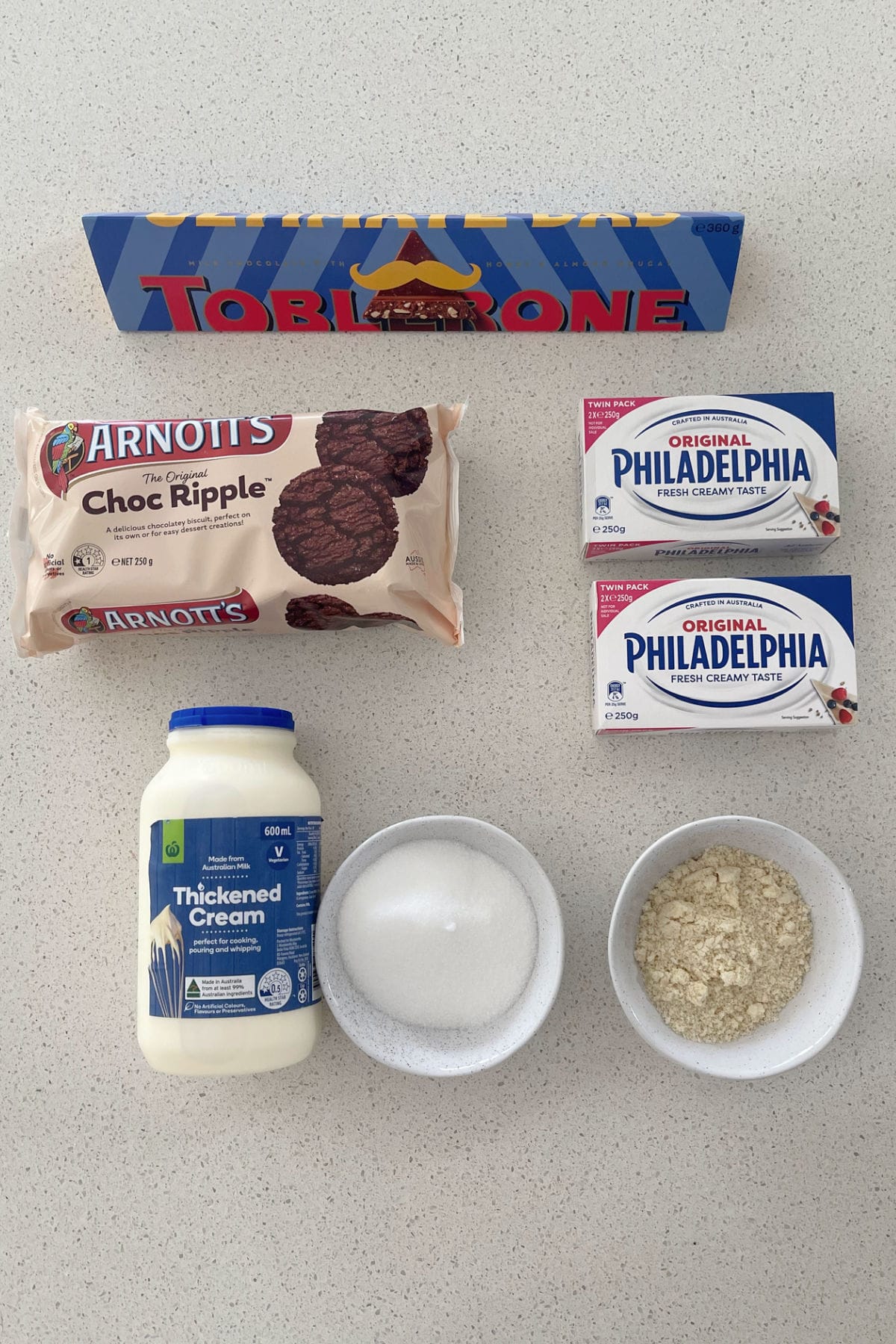 Ingredients to make a Toblerone Cheesecake on a benchtop.