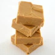 four slices of caramel fudge stacked on top of each other on a white background