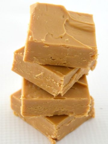 four slices of caramel fudge stacked on top of each other on a white background