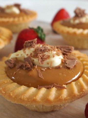 side view of caramel tarts on a wooden board