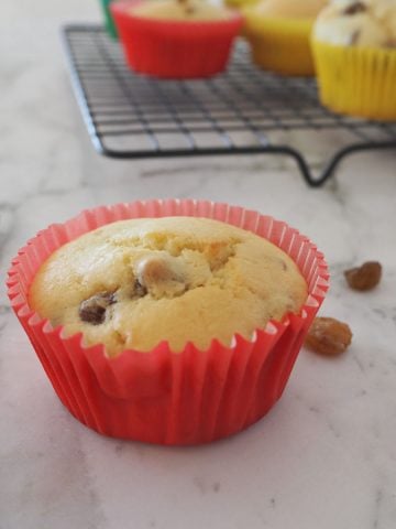 Raisin Muffin in red paper case on a marble background