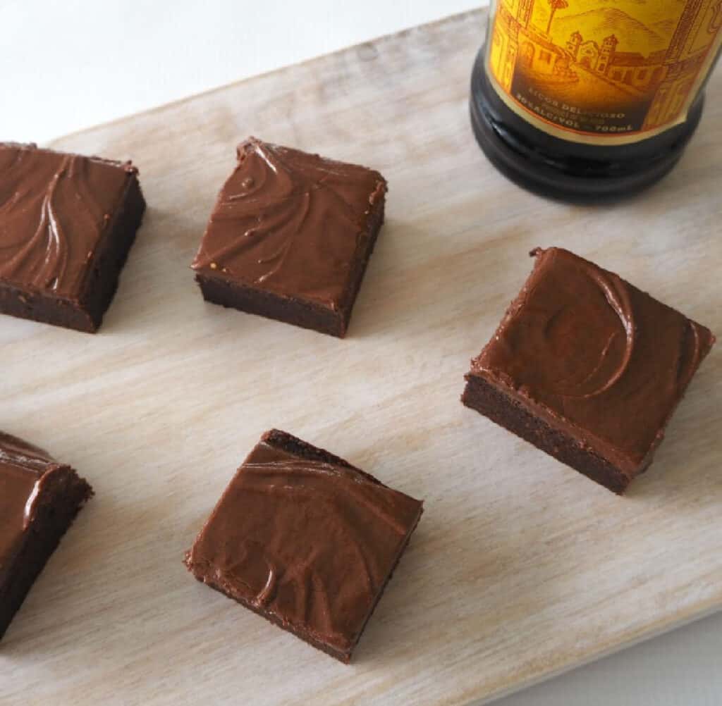 overhead view of brownie pieces on a wooden tray with a bottle of Kahlua in background