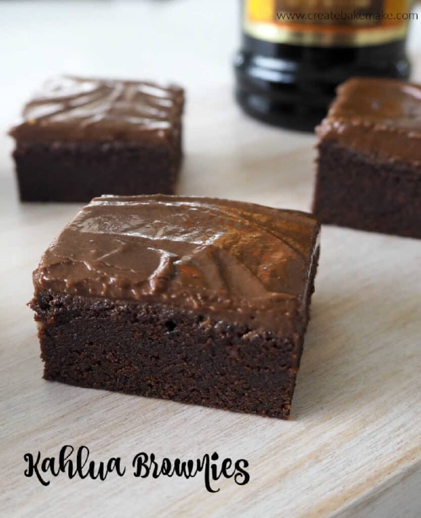 Kahlua Brownies on a wooden serving tray with a bottle of kahlua in the background
