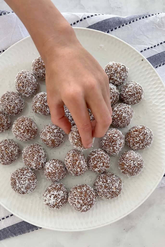 child's hand reaching for Rum Balls without Rum
