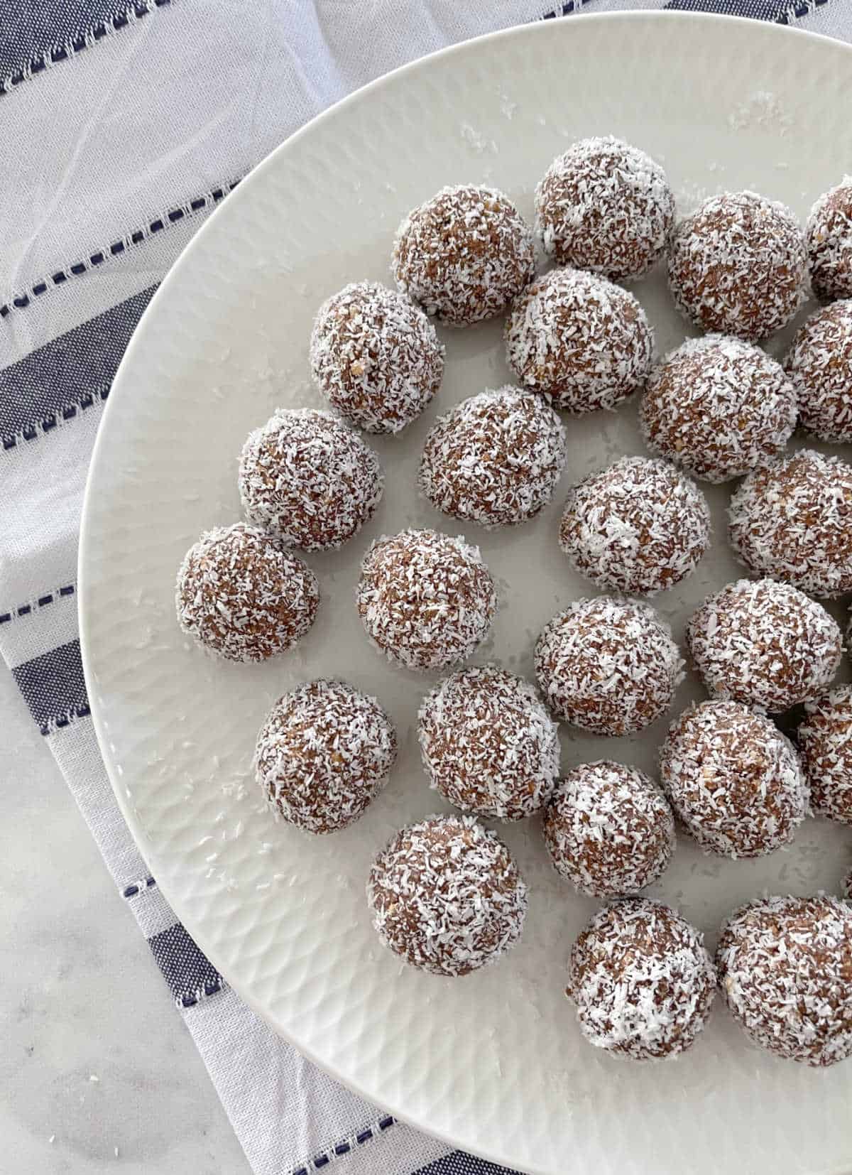 Kid Friendly Rum Balls on a white plate with blue striped towel underneath