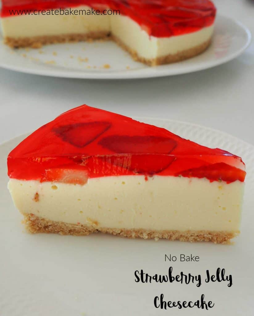 Strawberry Jelly Cheesecake slice on a white plate with full cheesecake behind it