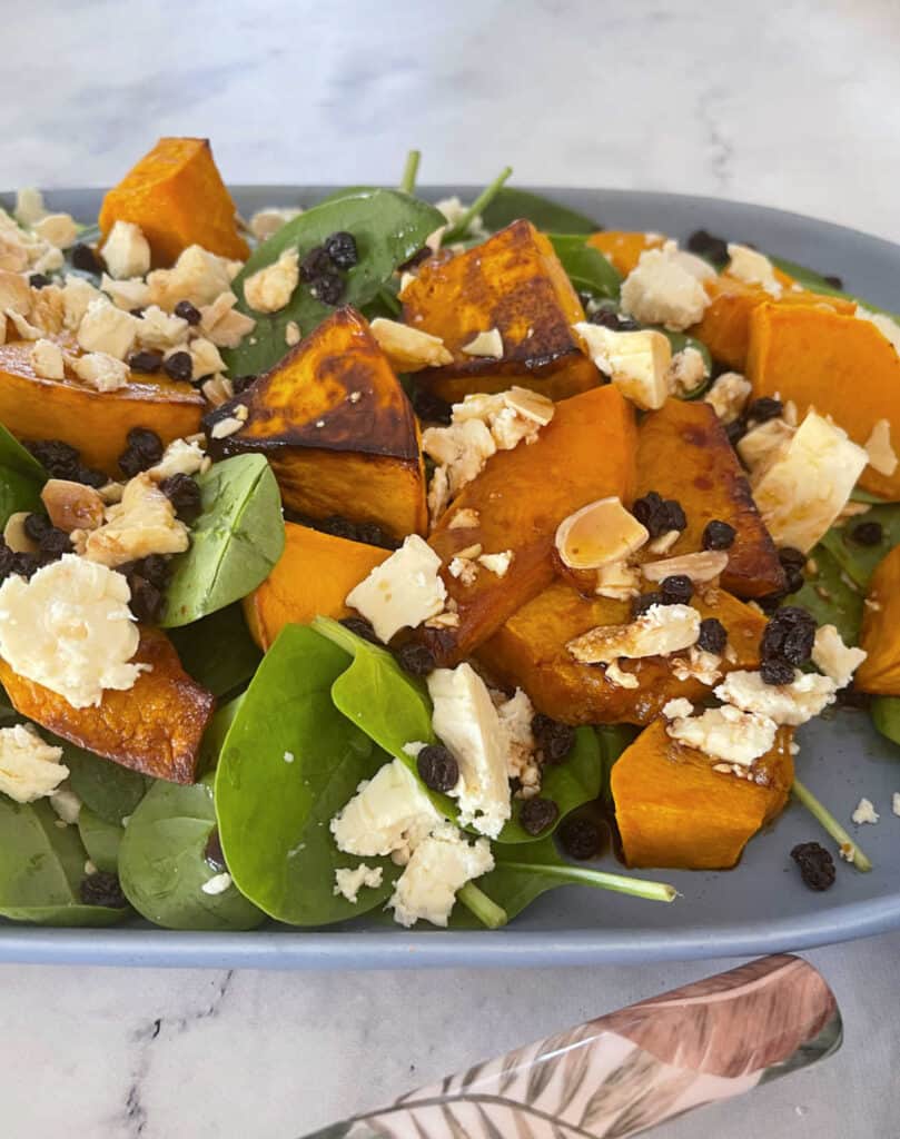 close up Roast Pumpkin Salad on a blue serving plate with a marble background