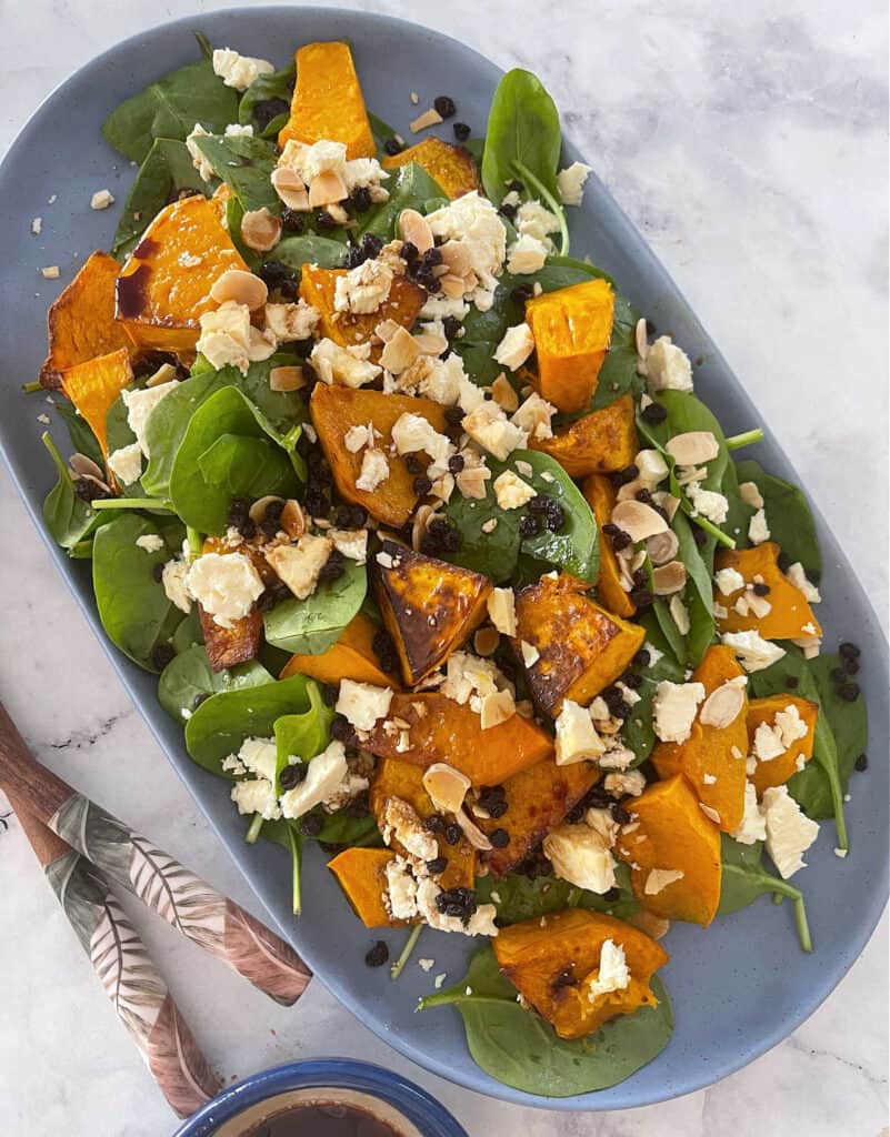 Roast Pumpkin Salad on a blue serving plate with a marble background