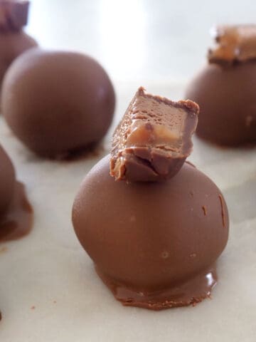 side view of close up of mars bar cheesecake balls on a marble tray