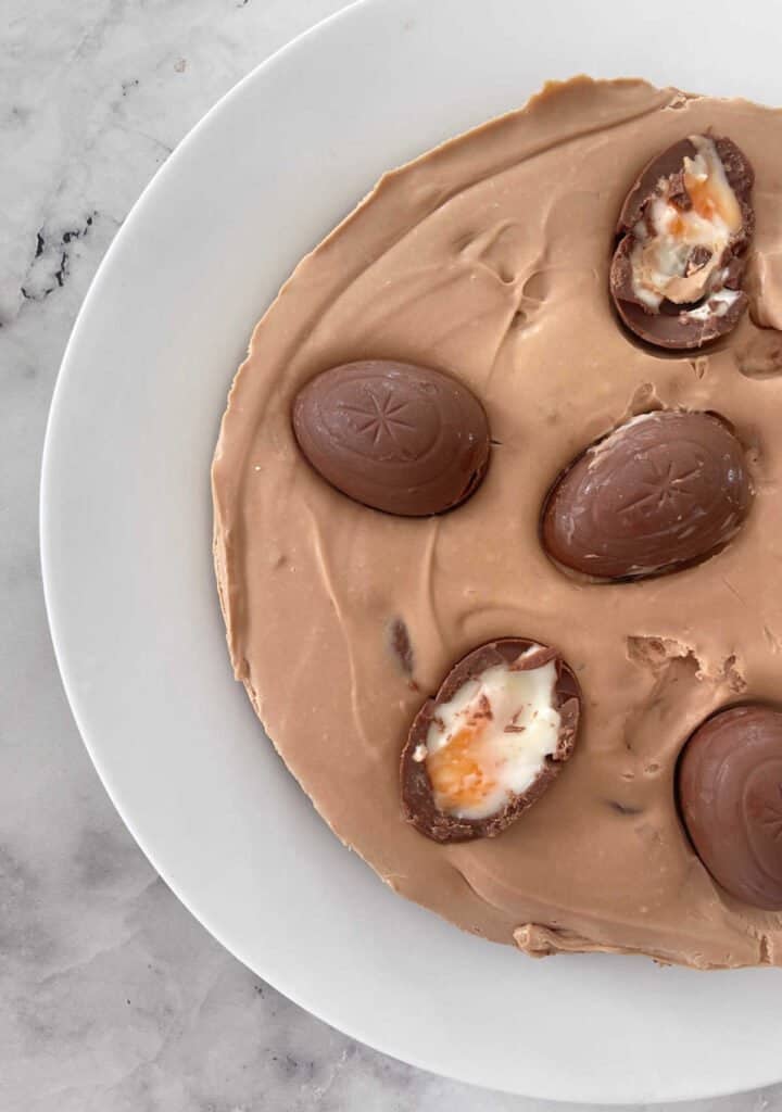 Top view of a Cadbury Creme Egg Cheesecake on a white plate.