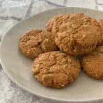 side view of six Anzac Biscuits on a specked plate.