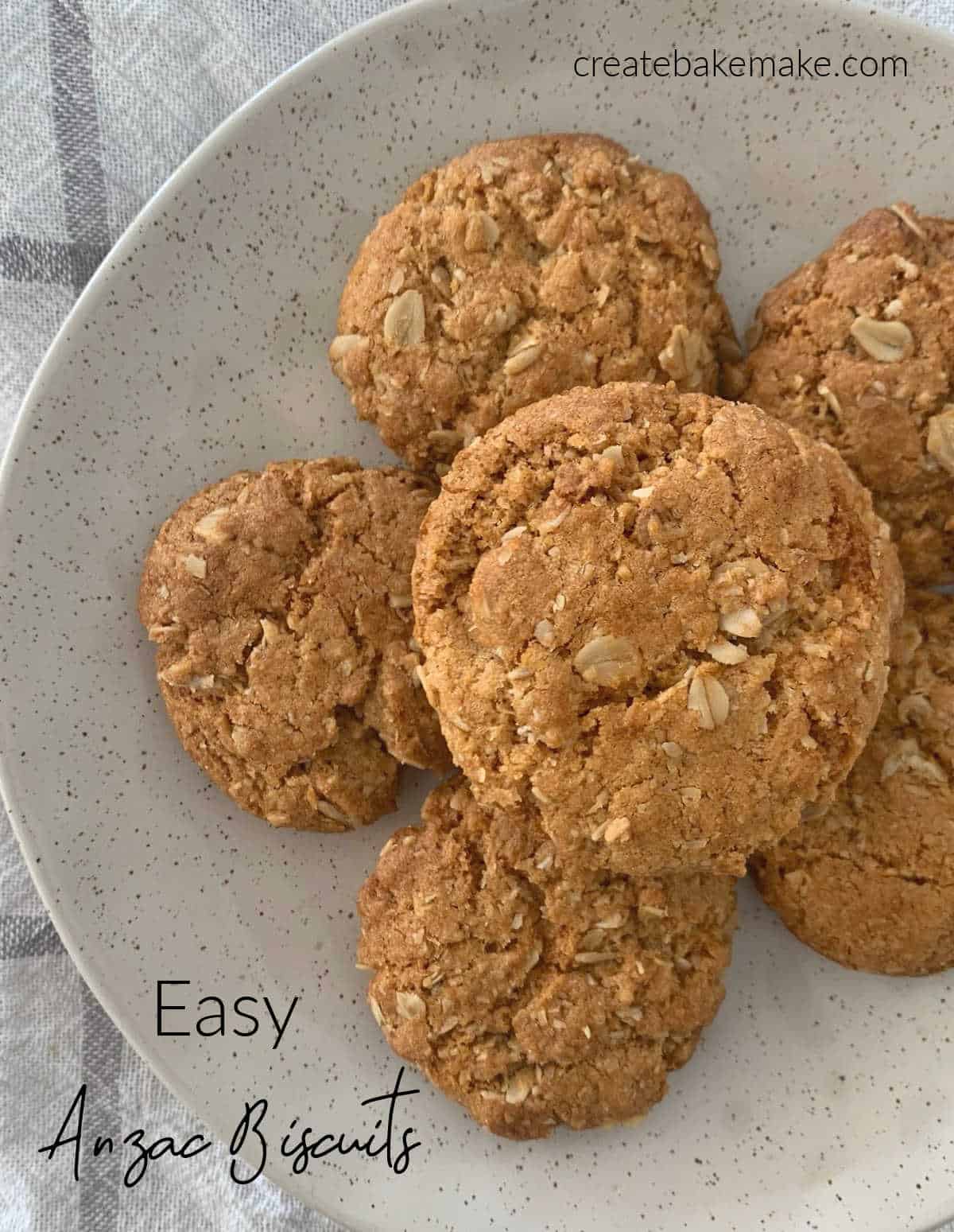 six Anzac Biscuits on a specked plate.
