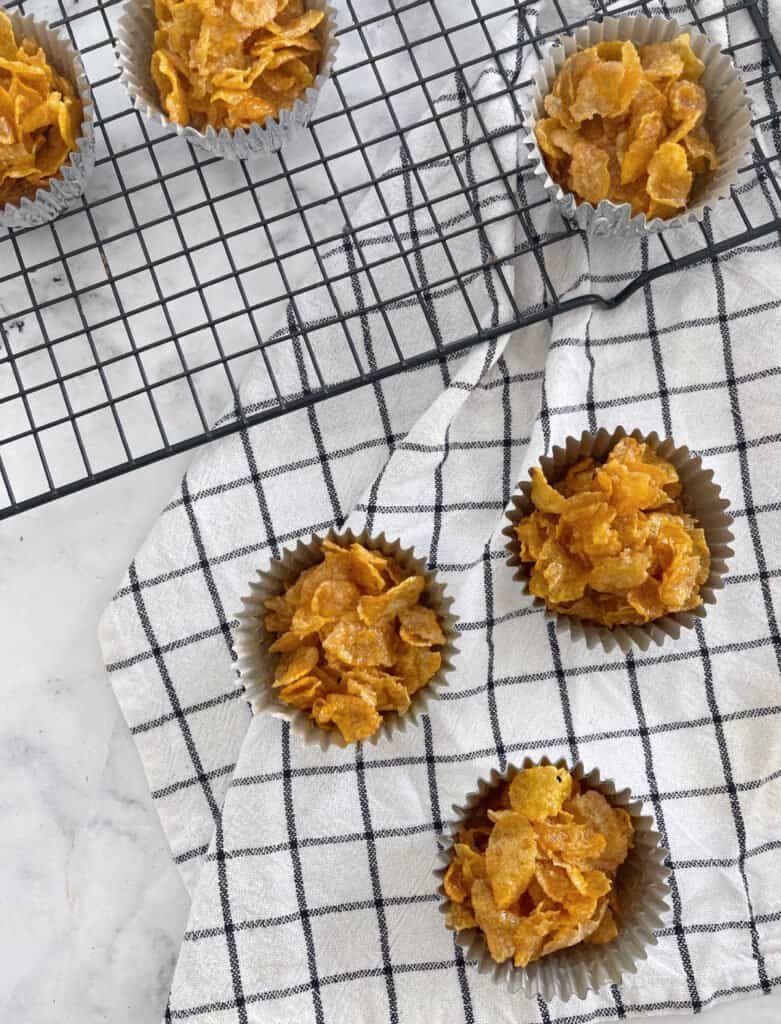 Three honey joys on a checkered towel with a wire baking rack.