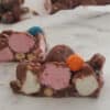 Slice of rocky road sitting on baking paper with more rocky road behind it.