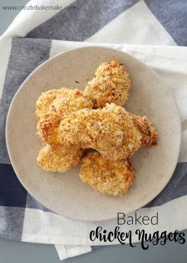 Homemade chicken nuggets piled on a speckled plate.