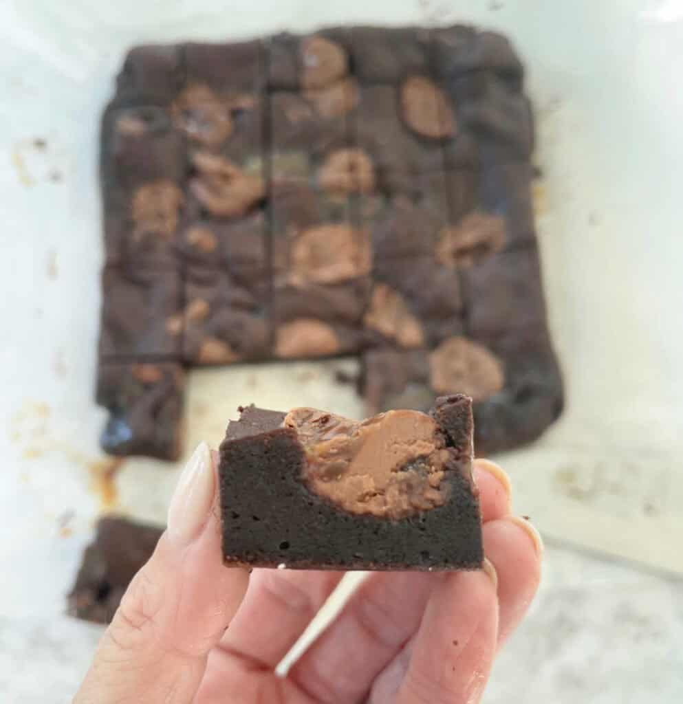Adult hand holding a piece of easter egg brownie.