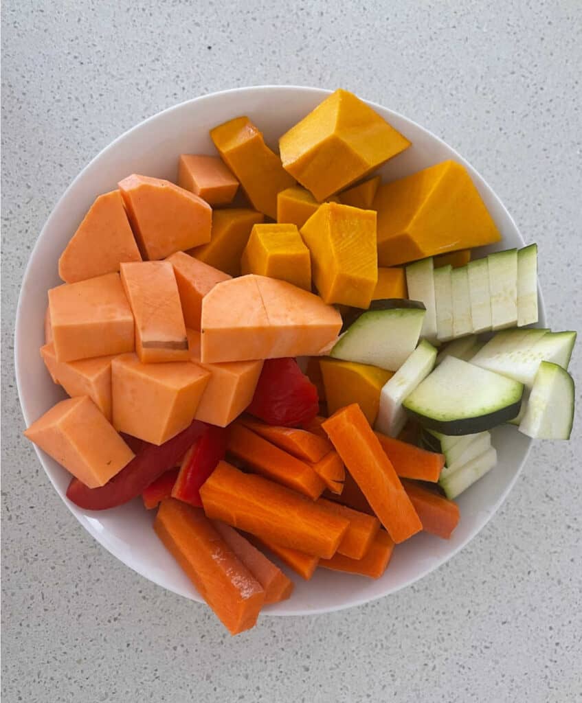 Vegetables cut into chunks sitting in a white bowl.