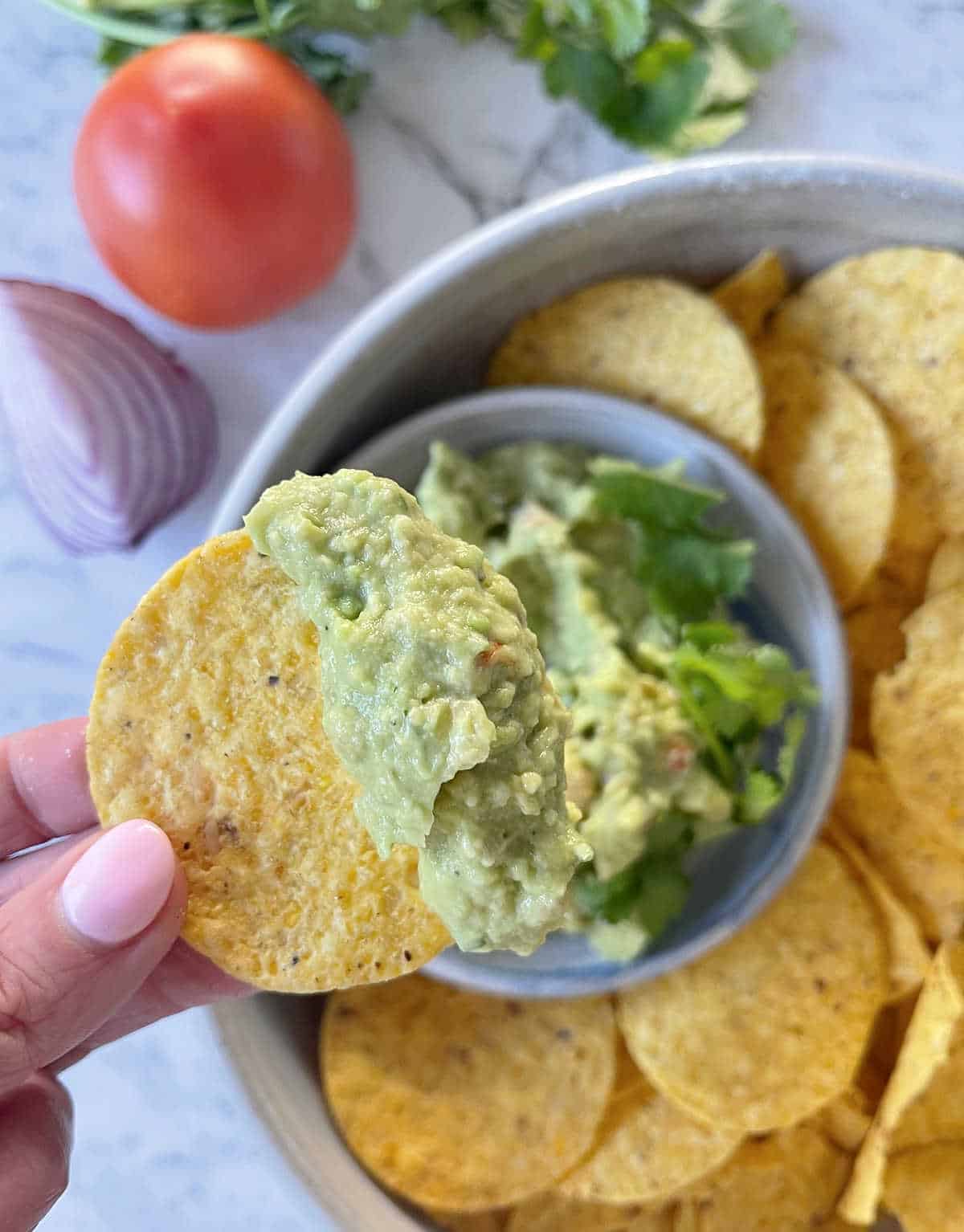 Corn chip scooping up guacamole.