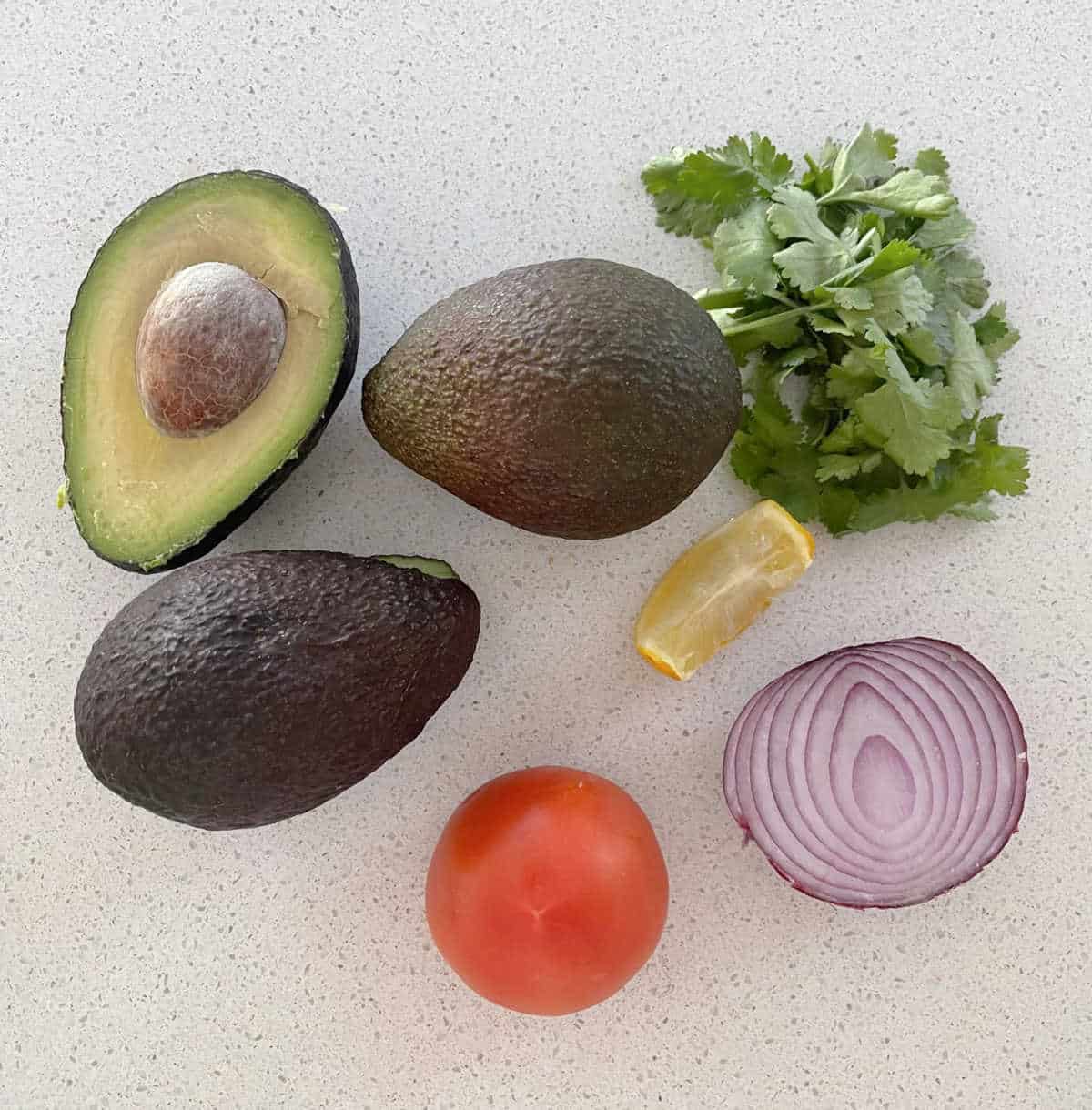 Guacamole ingredients on a bench top.