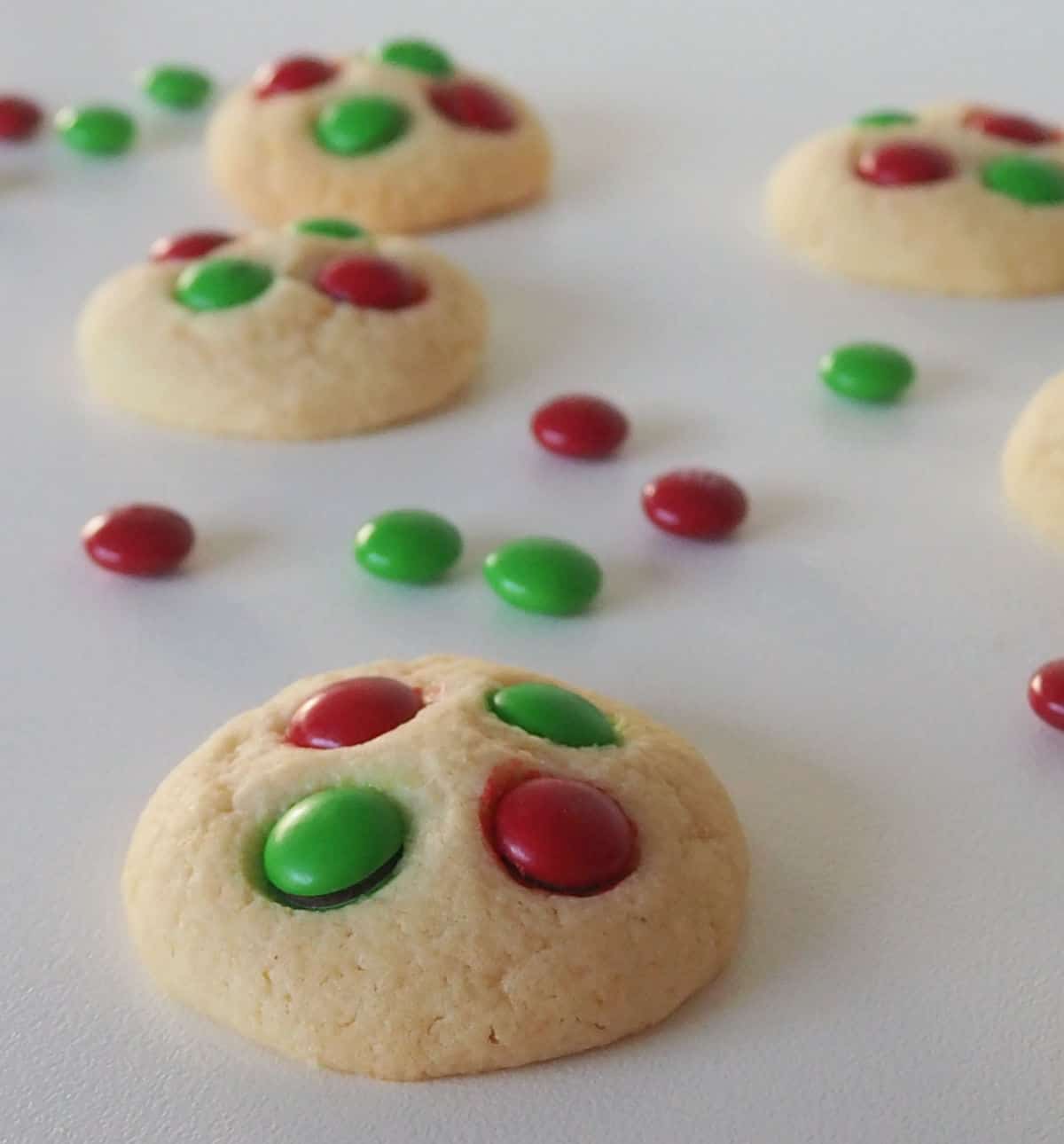 Vanilla Christmas Cookies on a white background with M&Ms scattered around.