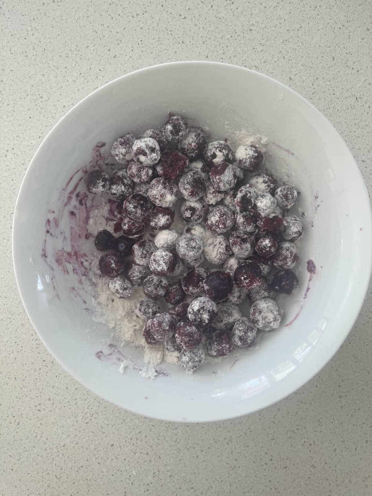 Blueberries in a bowl tossed in flour.