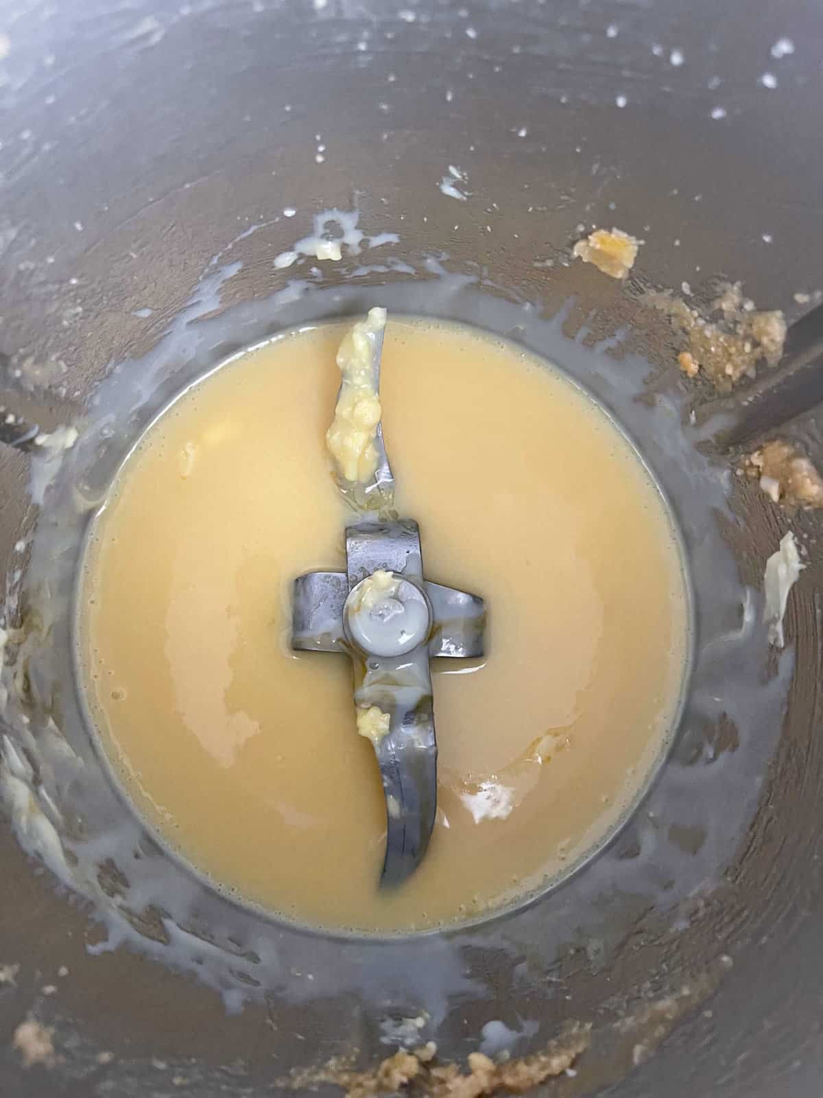 Melted butter and sweetened condensed milk in a Thermomix bowl.