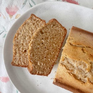 Banana Bread sliced and sitting on a white speckled serving tray.