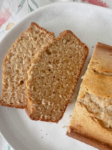 Banana Bread sliced and sitting on a white speckled serving tray.