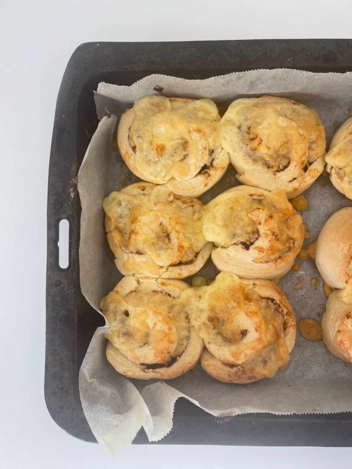 Vegemite and cheese scrolls in a baking tray straight after coming out of the oven.