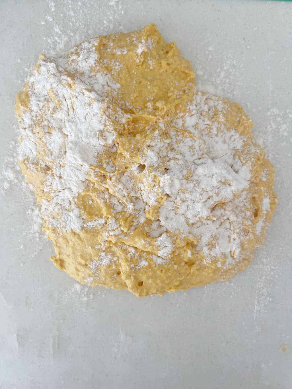 Pumpkin Scone mixture coated with flour on a bench top.