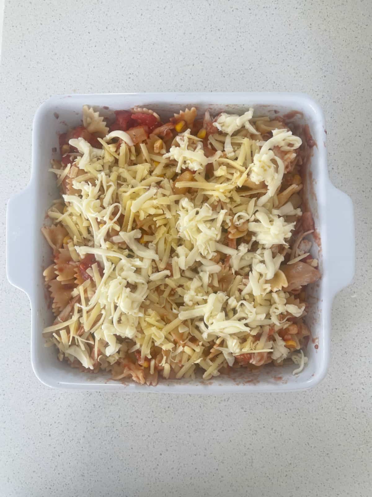 BBQ Chicken Pasta Bake topped with cheese ready to go into the oven.