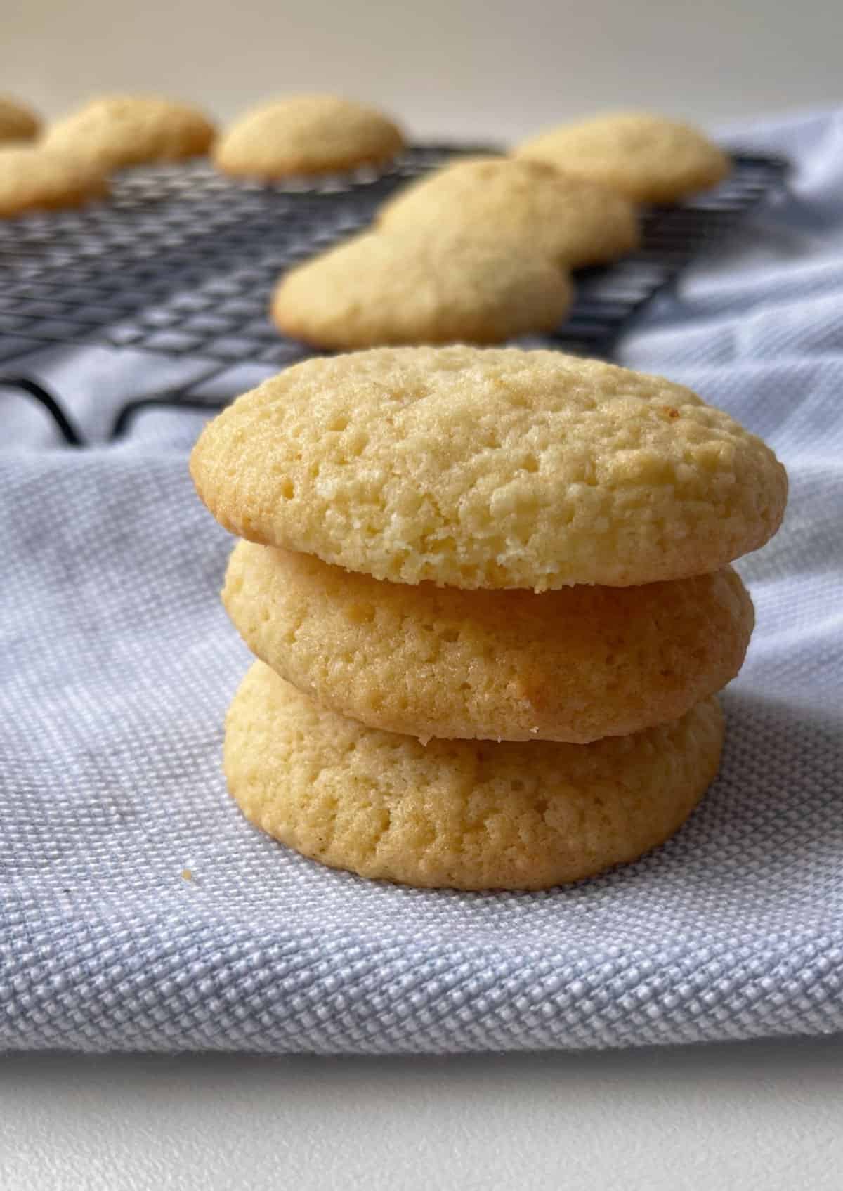 Side view of three coconut biscuits stacked on top of each other.