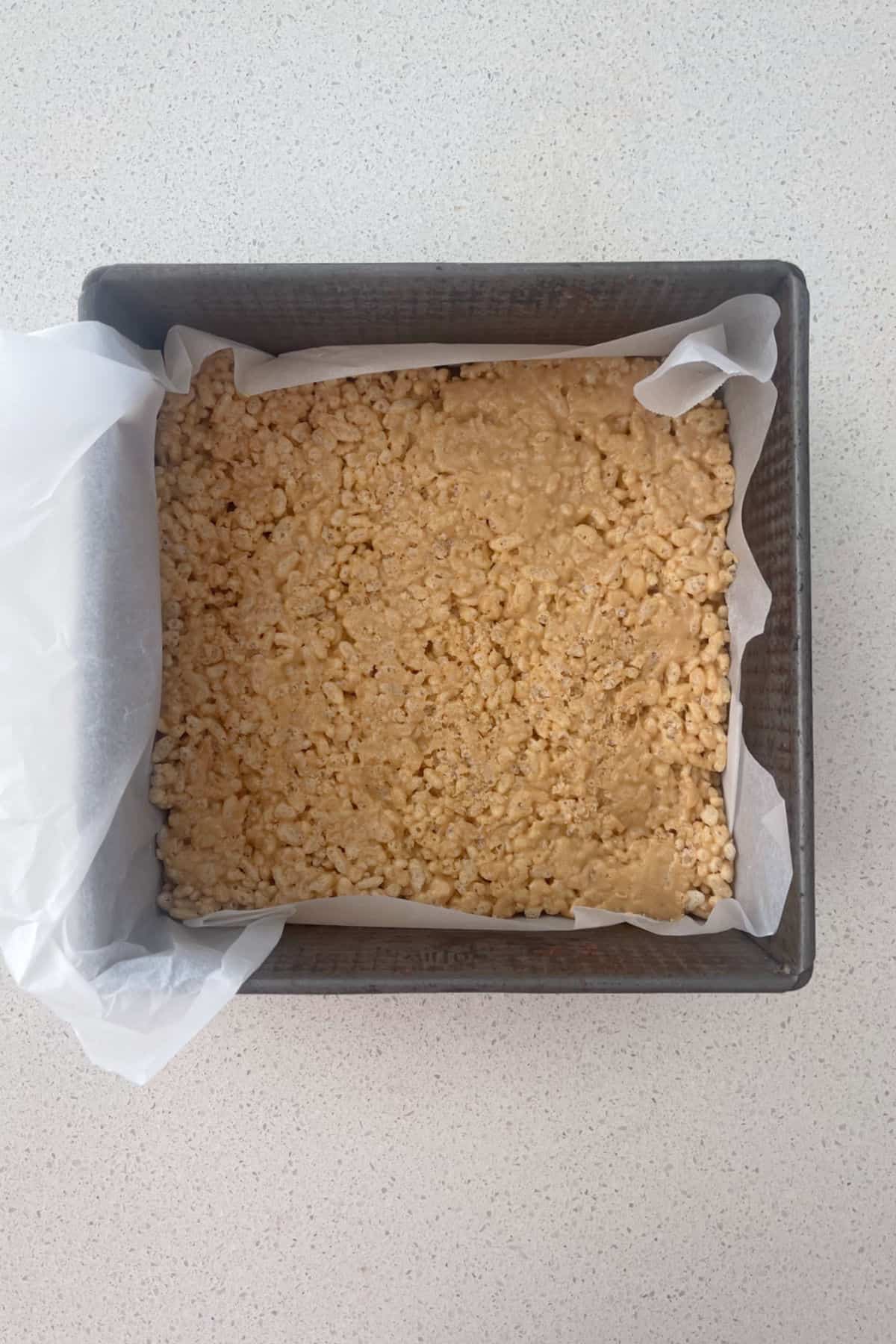 peanut butter rice bubble slice in a baking dish.