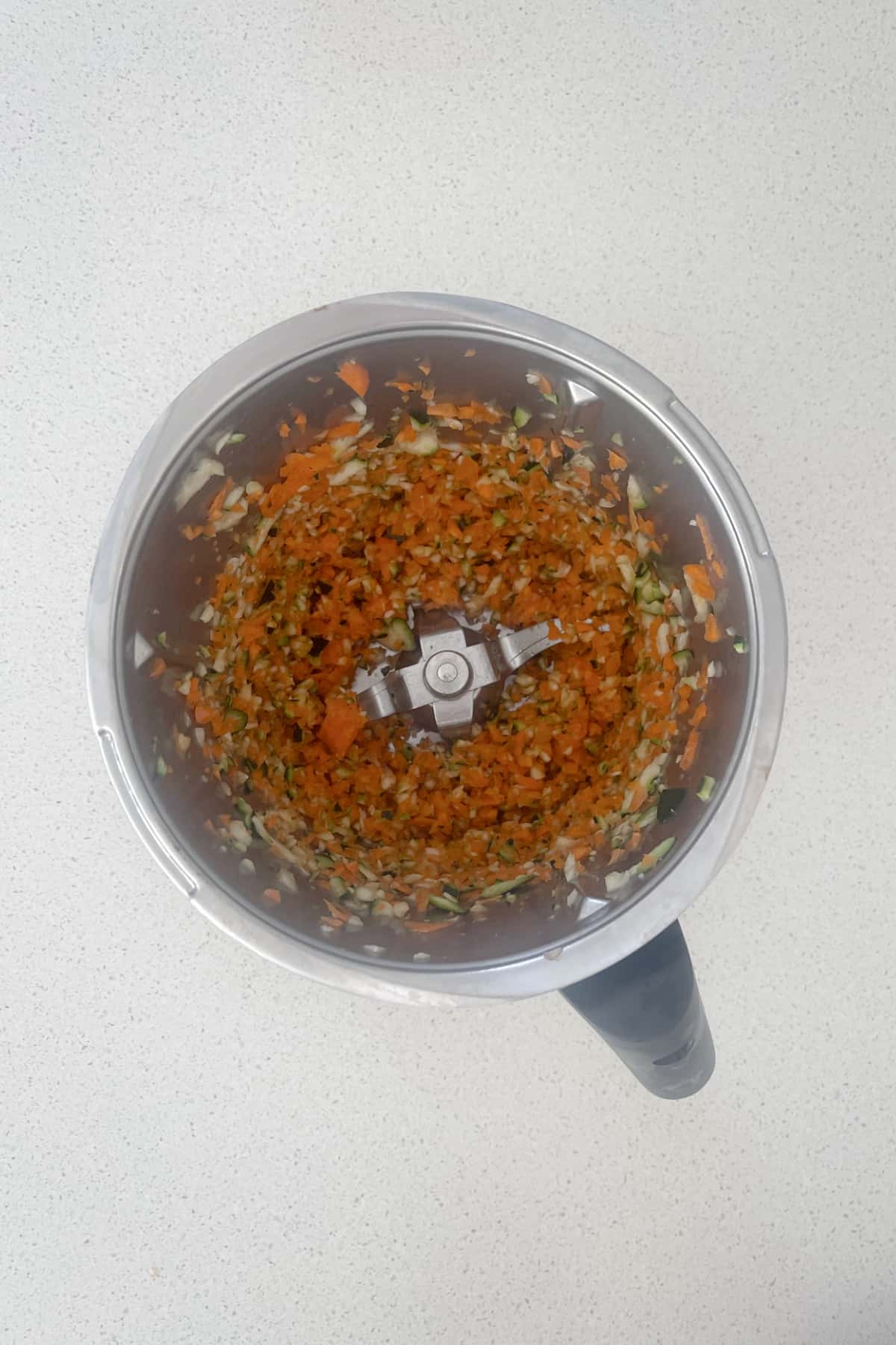 Grated carrot and zucchini in a thermomix bowl.