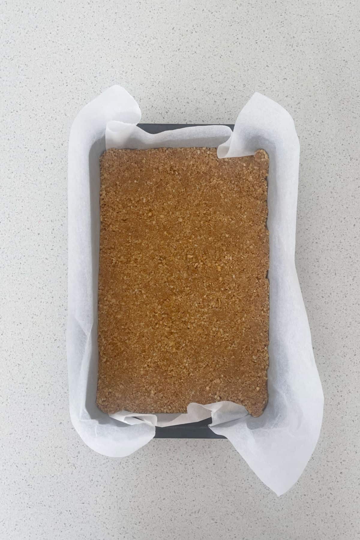 Biscuit base for jelly slice in a slice tray.