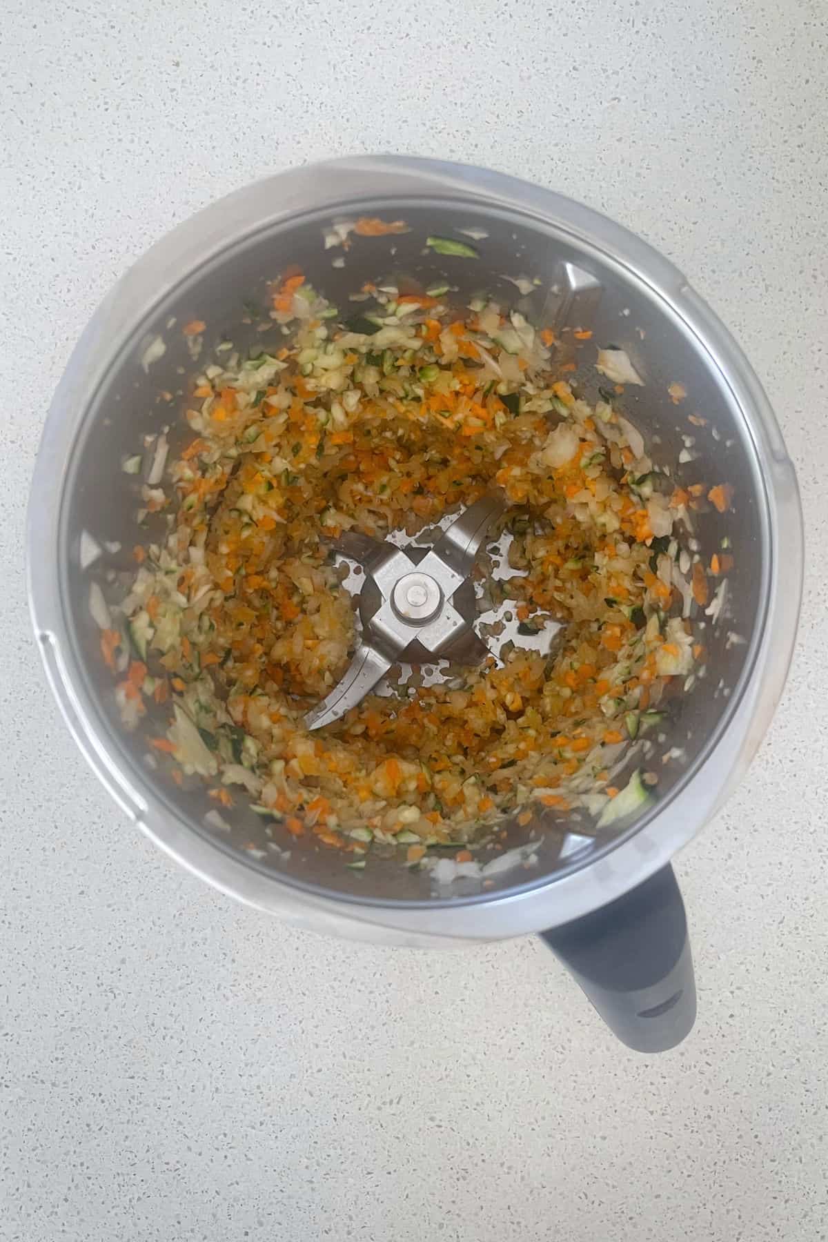 Grated vegetables in a Thermomix bowl.
