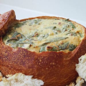 Side view of Spinach Cob Loaf with bread pieces surrounding it.