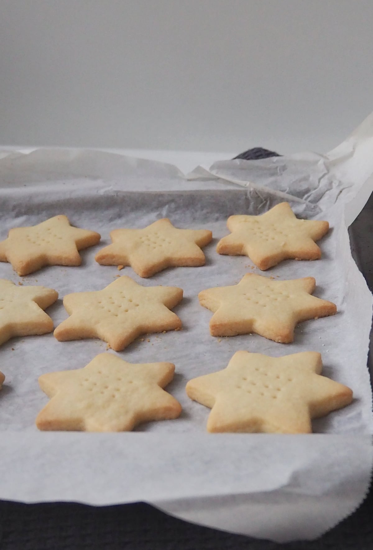 Shortbread Star biscuits on black baking tray.