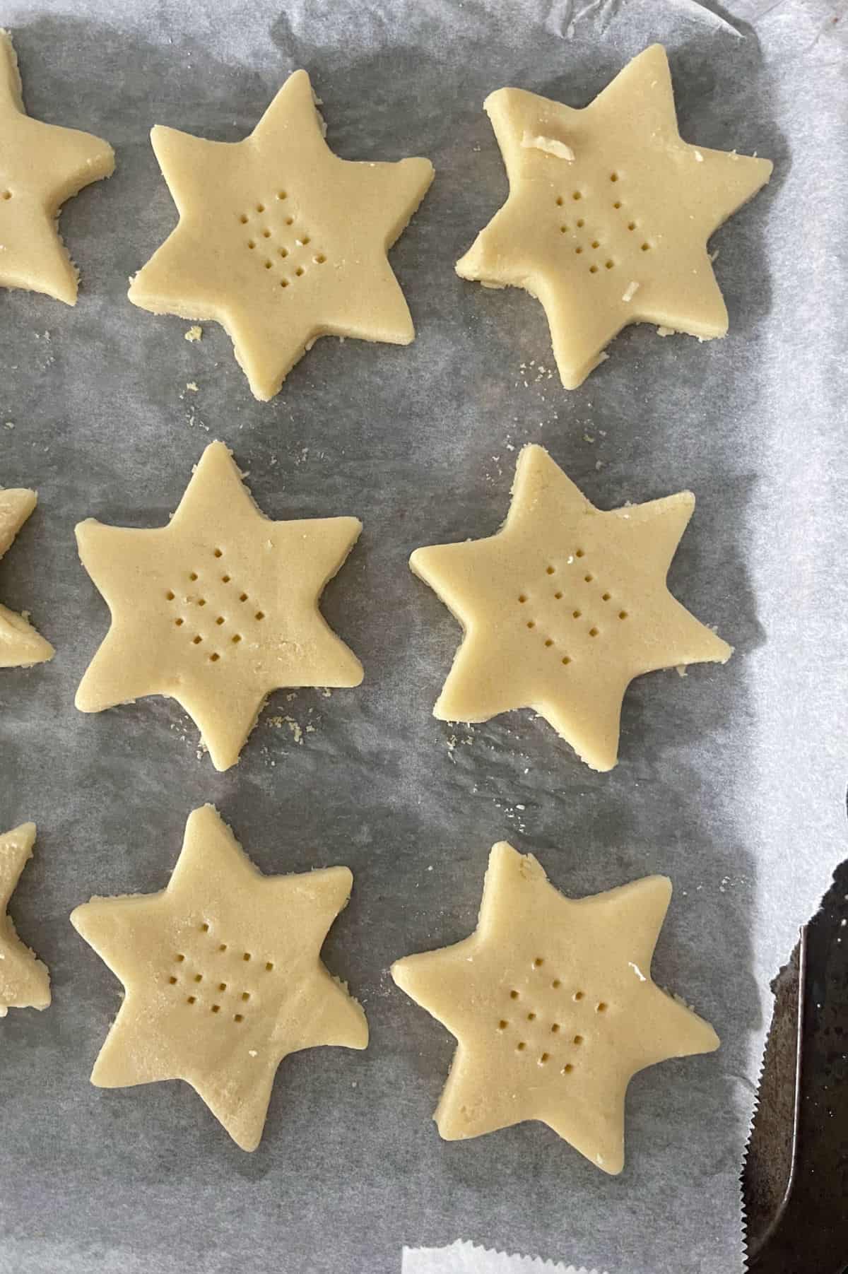 Shortbread stars on a baking tray lined with paper.