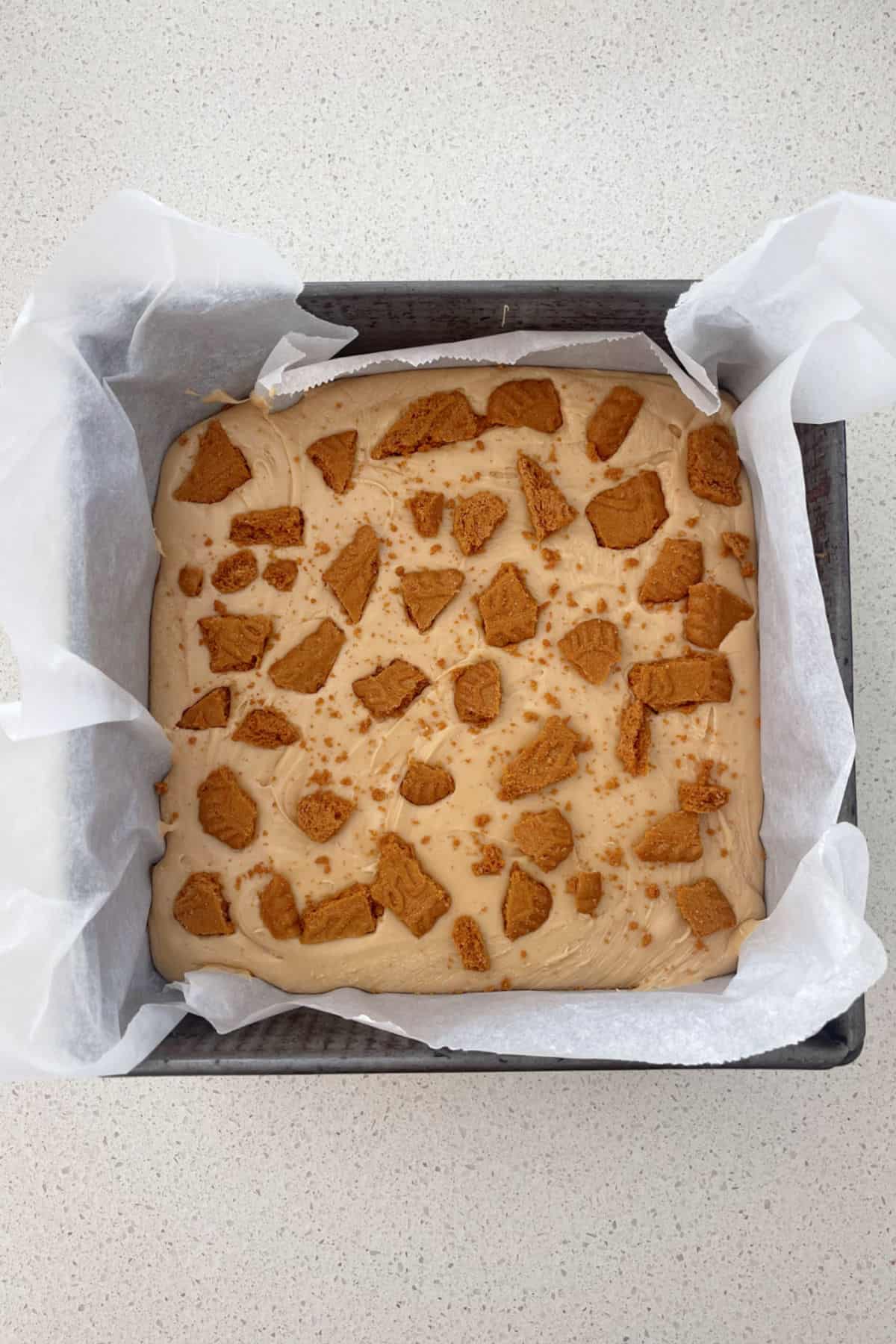 Biscoff Fudge in a lined baking tin ready to be put into the fridge.