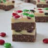 Two pieces of Christmas Slice on top of each other. Surrounded by M&M's and more pieces of slice.